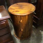 A hardwood drum style chest, the circular top above three drawers, raised on moulded base (60cm x