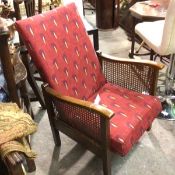 A 1920s oak framed cane side recliner chair upholstered in twenties style red fabric, on square