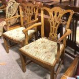 A pair of Edwardian mahogany Chippendale style open arm side chairs with inset needlework seats,