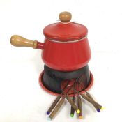 A Continental red enamelled fondue pan complete with cover and treen handle, with stand and base,