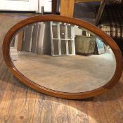 A mahogany oval framed wall mirror with bevelled glass plate (80cm x 55cm)