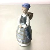 A Spanish Lladro porcelain figure, Woman with Basket, decorated with polychrome enamels (29cm x 10cm