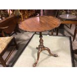 A Georgian style mahogany scalloped snap top occasional table, raised on turned carved baluster