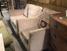 A modern two piece lounge suite comprising a two seater sofa and easy chair in fawn plush fabric, on