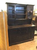 An elm Ercol dresser, the superstructure fitted three central shelves, flanked by glazed panel