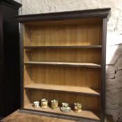 A 19thc stripped painted pine upright open bookcase fitted three adjustable shelves, on plinth