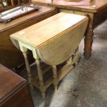 An oval bleached oak drop leaf gateleg tea table, raised on turned baluster supports (71cm x 75cm