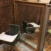 A modern gilt framed wall mirror with scrolling floral border and bevelled glass plate (117cm x