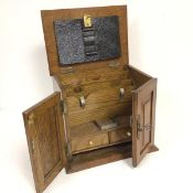 An Edwardian oak stationery cabinet, the top above a pair of panel doors enclosing a fitted