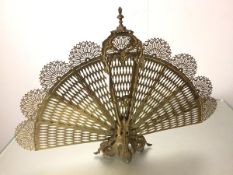 A cast brass Edwardian style peacock fan firescreen raised on cast acanthus leaf base (61cm x 85cm