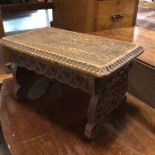 An Edwardian relief carved stool, the rectangular top with moulded edge and relief carved frieze