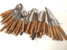 A collection of 1960s/70s teak handled stainless steel flatware including soup spoons, dessert