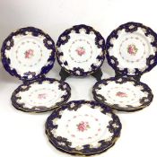 A set of eight Royal Crown Derby porcelain plates decorated with central floral panels enclosed