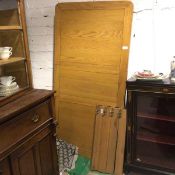 An oak panel top kitchen dining table, with inset extra leaf, raised on square moulded supports (