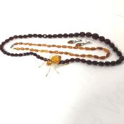 A Russian amber mounted spider brooch (6cm), a natural amber bead necklace (21cm), a red amber