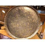 A Persian brass circular tray with engraved and embossed hunting scene, with figures, deer and dogs,