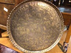 A Persian brass circular tray with engraved and embossed hunting scene, with figures, deer and dogs,