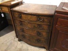 A reproduction walnut bow front chest fitted four graduated long drawers, with shaped apron, on