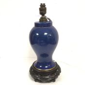 A baluster lamp with hardwood associated stand, with lapis style blue glazed decoration and gilt