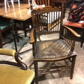 An Edwardian stained beech Arts & Crafts style spindle back chair with inset leather seat, on ring