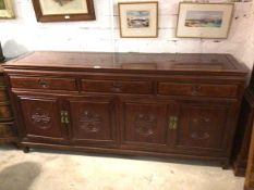 A Chinese cherrywood side cabinet, the rectangular top with moulded edge above three frieze