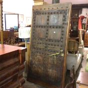 A Moroccan hardwood and oak mounted panel door, with studded brass star like detail and strap side