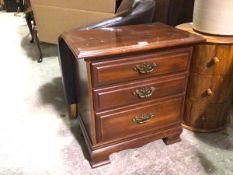 A mahogany bedside, the rectangular top with moulded edge above three graduated long drawers, on