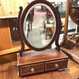 A 19thc mahogany swing mirror, with satinwood border, raised on scroll end supports, fitted two