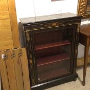 A Victorian ebonised side cabinet, the rectangular top with moulded edge above an inlaid brass