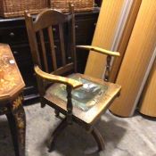 An Edwardian beech spar back adjustable business armchair, with green leather inset seat on bipod