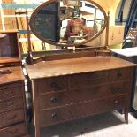 An Edwardian mahogany dressing chest, the oval mirror above a pierced gallery fitted two centre