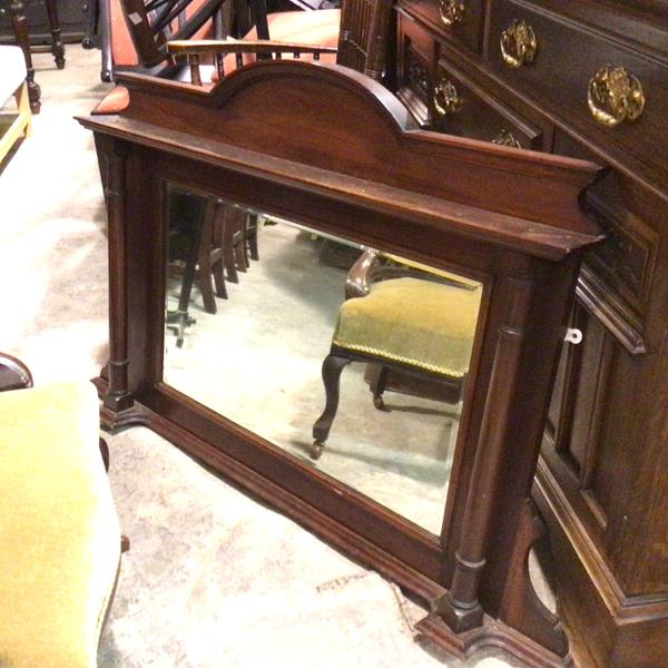 An Edwardian walnut overmantel with arched top above a rectangular frame bevelled glass wall mirror,