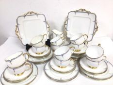 A Paragon china Art Deco inspired forty piece tea service with stylised flower, gold and blue