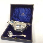 A George III style Sheffield silver scalloped sauceboat, raised on pad feet, complete with serving