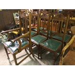 An Edwardian set of six plus one oak dining chairs with acanthus leaf relief carved arched backs,