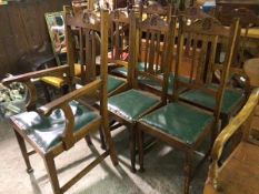 An Edwardian set of six plus one oak dining chairs with acanthus leaf relief carved arched backs,