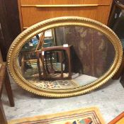 An Edwardian oval gilt framed wall mirror with beaded double border (76cm x 102cm)