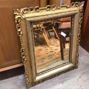 An Edwardian gilt wall mirror with composition acanthus leaf outer frame and inner beaded frame (