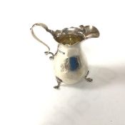 A Sheffield silver Georgian style miniature cream ewer with scalloped top and C scroll handle to