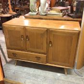 An Ercol elm sideboard, the rectangular top with moulded edge above a single long panel door,