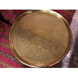 A heavy Eastern brass engraved circular tray, with animal and figure panels enclosed within