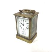 An Edwardian brass four glass carriage clock with enamelled dial and roman numerals, and