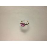 A pink tourmaline and diamond ring, the round-cut tourmaline claw-set on diamond-set shoulders, each