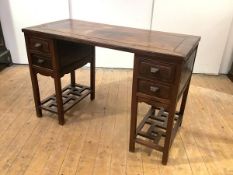 An early 20th century Chinese Export padouk wood desk, the rectangular detachable top raised on a