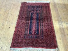 A Turkoman prayer rug, with central indigo mirhab within multiple geometric floral and scroll