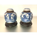 A pair of Chinese blue and white crackle-glazed jars and covers, each decorated with mothers and