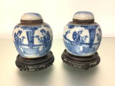 A pair of Chinese blue and white crackle-glazed jars and covers, each decorated with mothers and