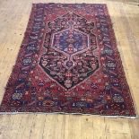 A North-West Persian rug, the central medallion within an indigo field with madder spandrels and