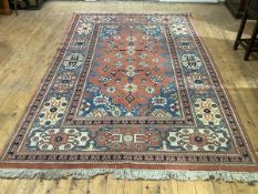 A small hand-knotted Heriz carpet, the terracotta field decorated with stylised flowers and