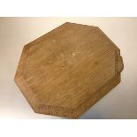 Workshop of Robert (Mouseman) Thompson, a shaped octagonal oak cheese or bread board, with carved